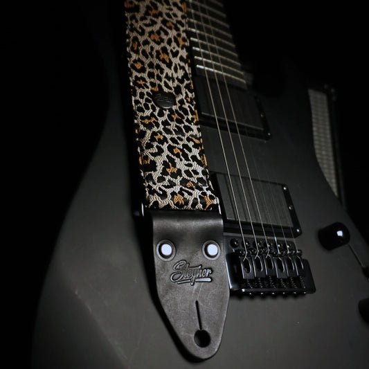 Hochwertiger, rutschfester Gitarrengurt im schimmernden Leopardenmuster, montiert an einer E-Gitarre, handgefertigt in Deutschland.