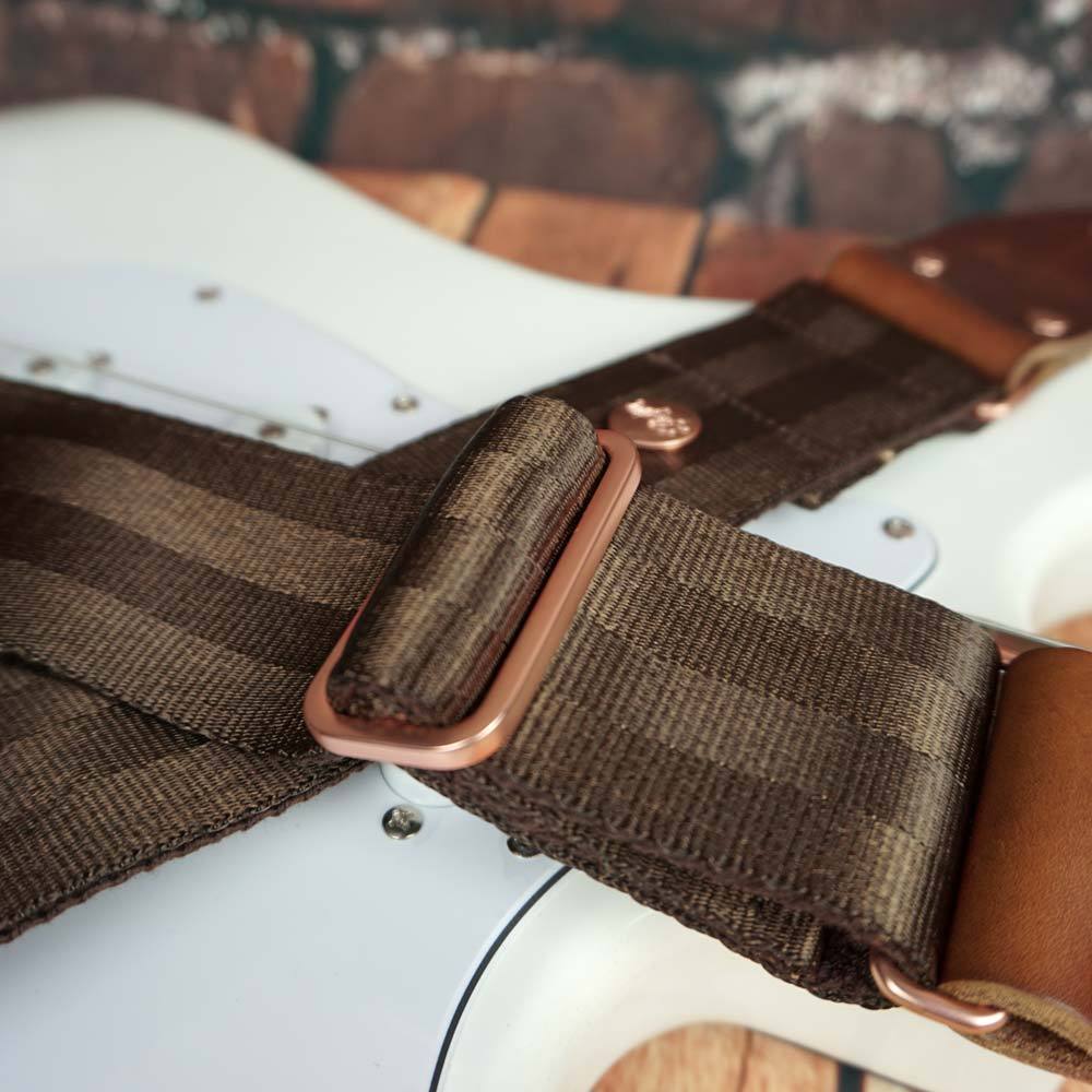 Gitarrengurt braun aus Sicherheitsgurtband Autogurtband bequem und rutschfest auf einer weißen Gitarre