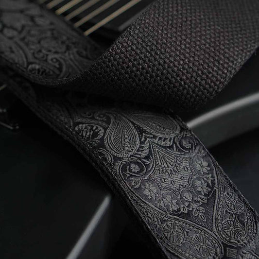 Wunderschöner besonderer Premium Gitarrengurt in schwarz mit Paisley Muster auf einer schwarzen Ibanez E-Gitarre