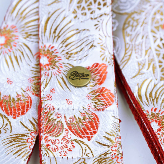 Gitarrengurt weiss mit buntem retro Blumen Muster und Marken Logo Steyner