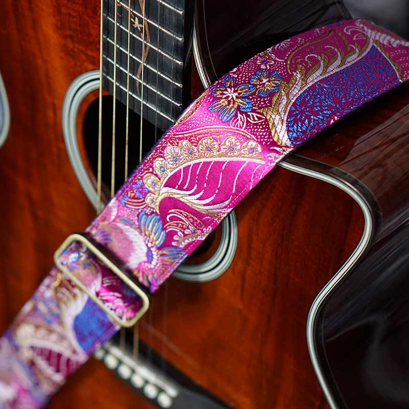 Pinker Gitarrengurt mit Blumen Muster in Glanz Optik auf einer Taylor Akustik Gitarre