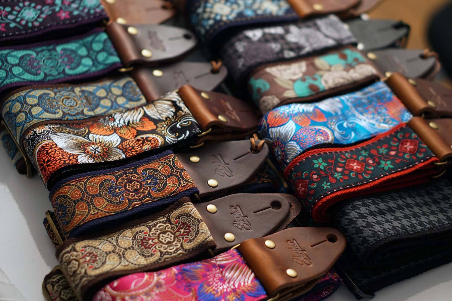 Große Auswahl an bunten Gitarrengurten mit verschiedenen Mustern für Gitarrem