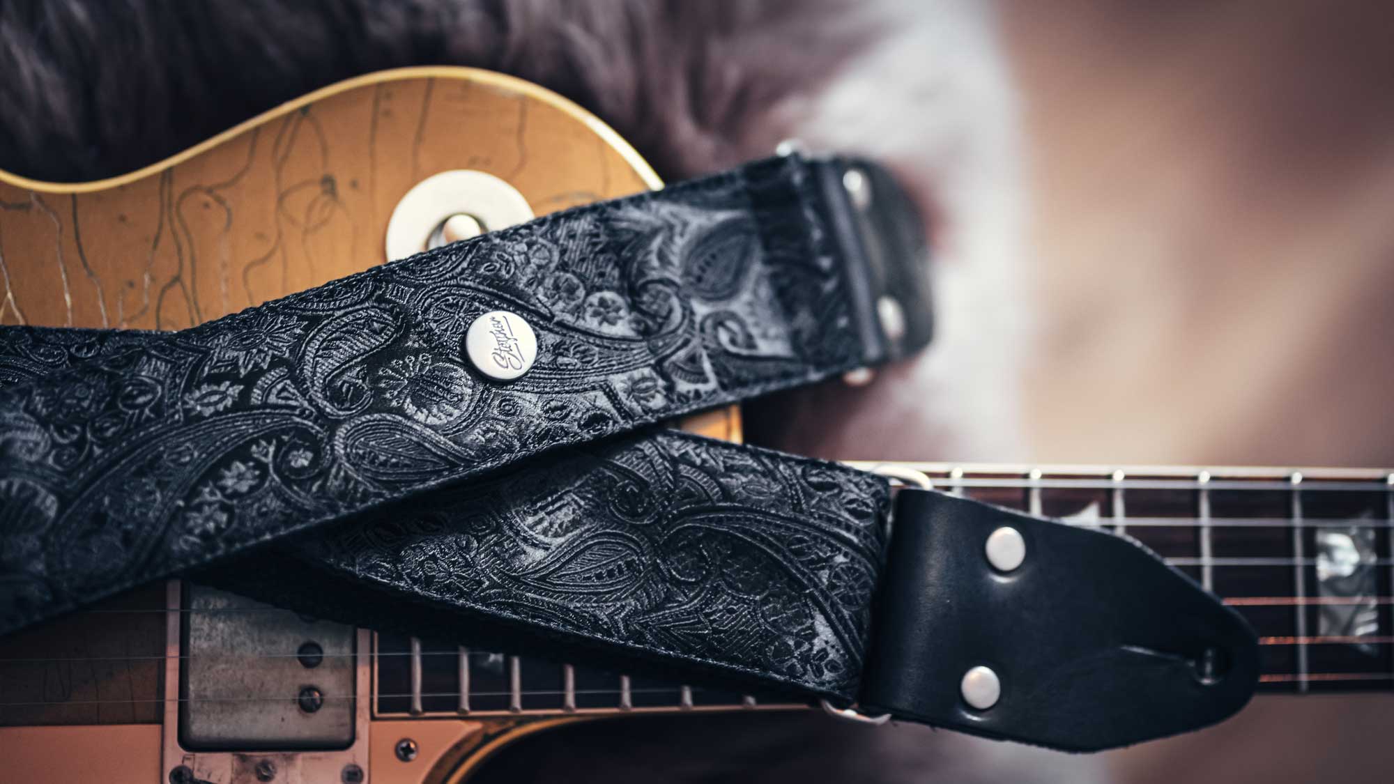 einfarbiger Gitarrengurt in schwarz mit Paisley Muster auf einer Vintage Gitarre Les Paul von Gibson mit Gold Top