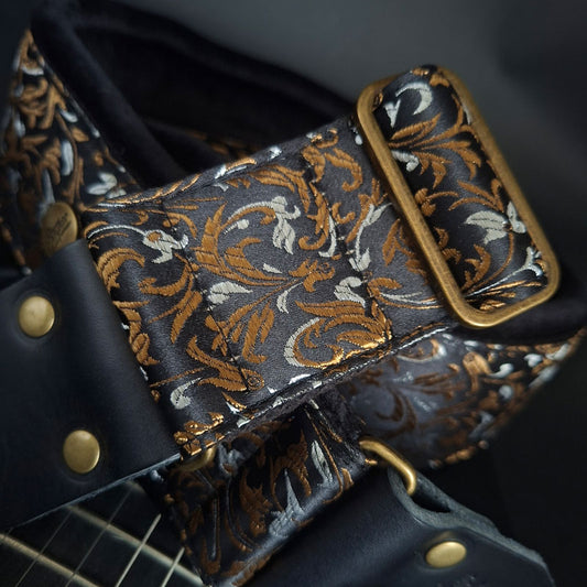 Gepolsterter Premium Gitarrengurt Luxury Black Gold Baroque in Schwarz-Gold-Silbe – sehr bequem , 7 cm Breit , made in Germany mit Jacquardmuster, goldenen Akzent und robusten Lederenden von Steyner Straps.