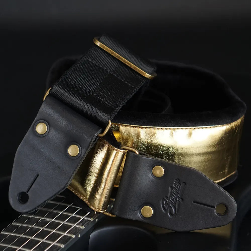 Premium Gitarrengurt aus goldenem Kunstleder mit schwarzem, dickem, weichem Polster – handgefertigt von Steyner Straps in Deutschland, luxuriöses Design für E-Gitarre und Bass.
