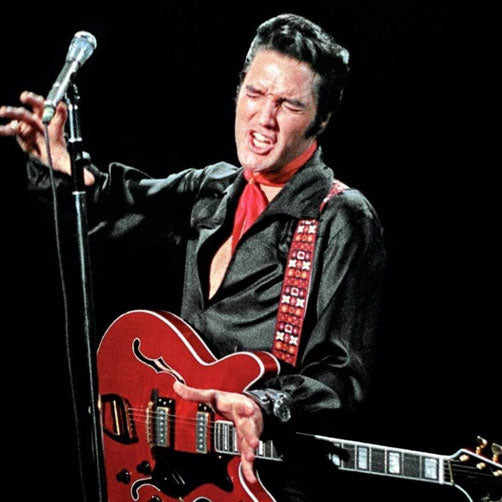 Elvis Presley auf der Bühne mit roter Jazz Gitarre und einem Retro Gitarrengurt