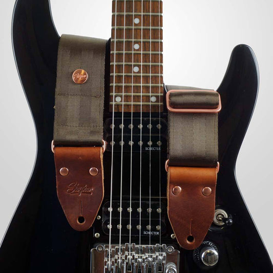 Gitarrengurt braun aus Sicherheitsgurtband Autogurtband auf einer schwarzen Gitarre