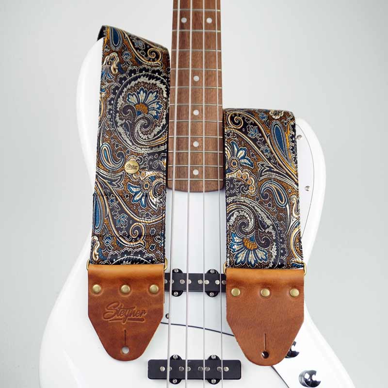 Bester Bassgurt und Gitarrengurt in schwarz mit Paisley Muster auf einem weißen E  Bass