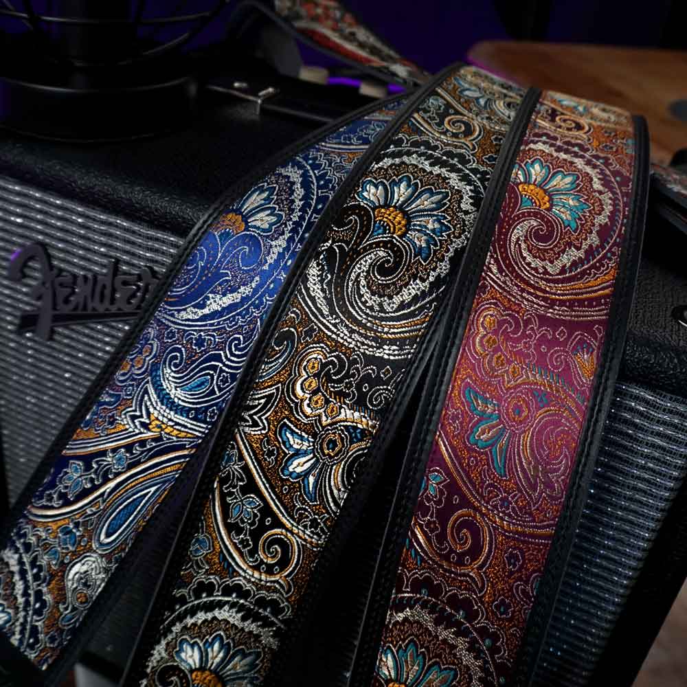 Drei außergewöhnliche Steyner Lights Gitarrengurte mit buntem Paisley-Muster in Blau, Schwarz und Rot, Made in Germany