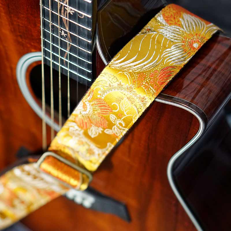 Gelber edle Gitarrengurt aus Seidenstoff auf einer Taylor Akustikgitarre