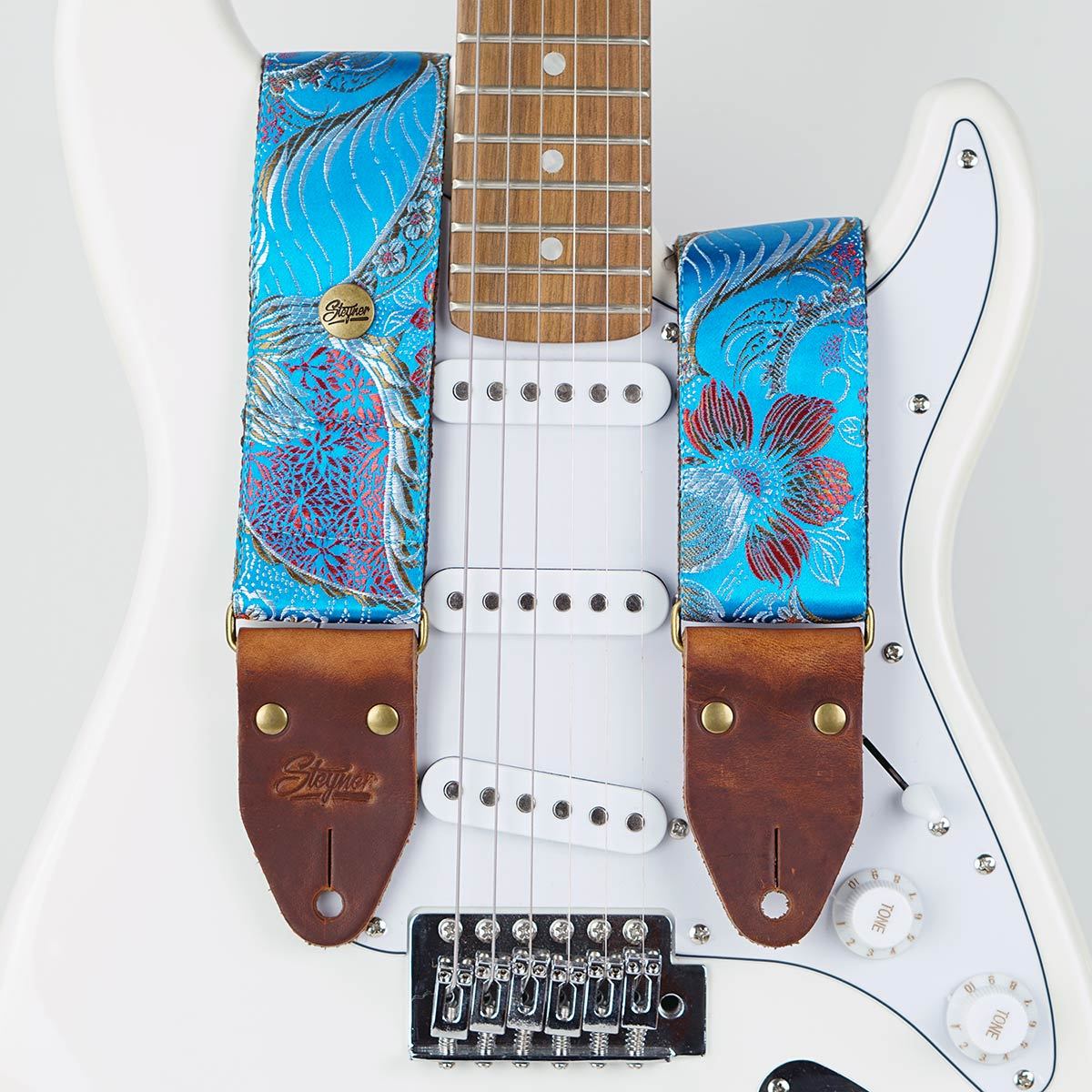 Gitarrengurt blau vintage - retro stil mit Blumen Muster bunt auf einer weißen E Gitarre