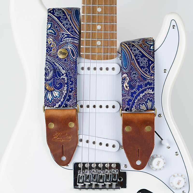 Gitarrengurt blau mit Blumen Muster Paisley auf einer weißen Fender E Gitarre