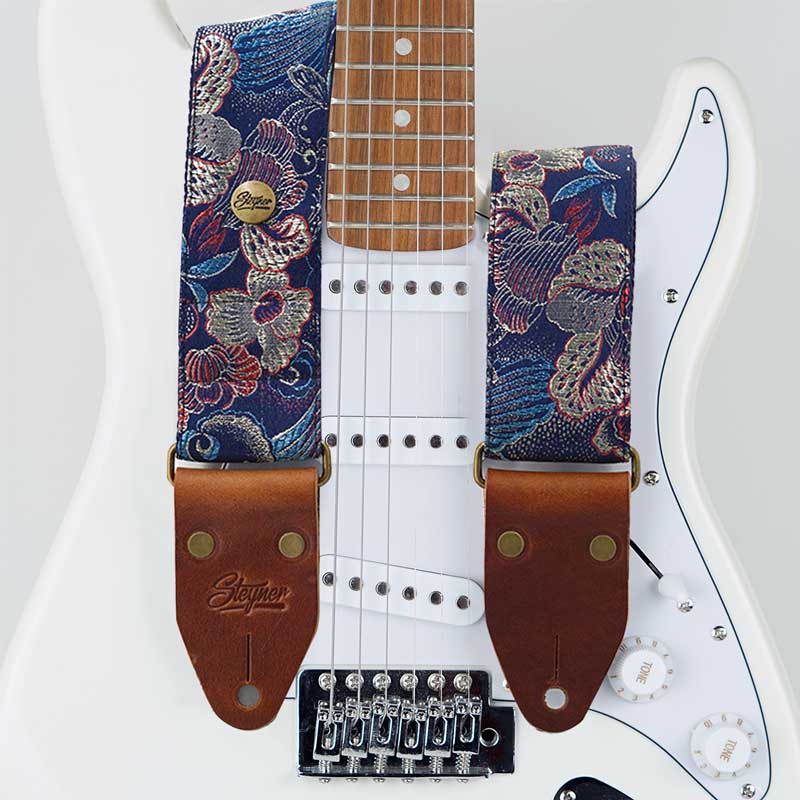 Gitarrengurt blau im vintage Stil mit Blumen Muster auf einer weißen E-Gitarre