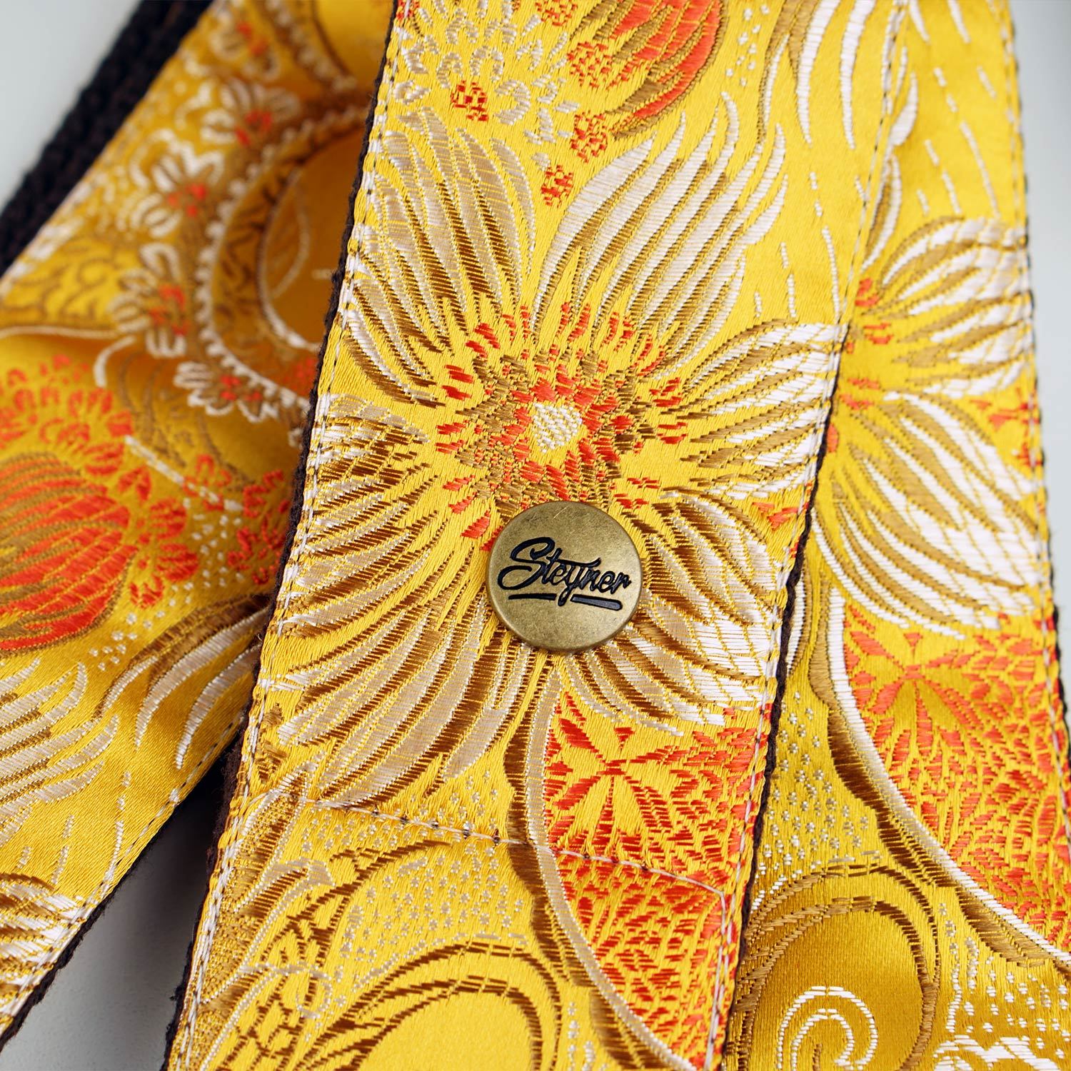 Gitarrengurt gelb mit Blumen Muster bunt - Detailaufnahme mit Marken Logo