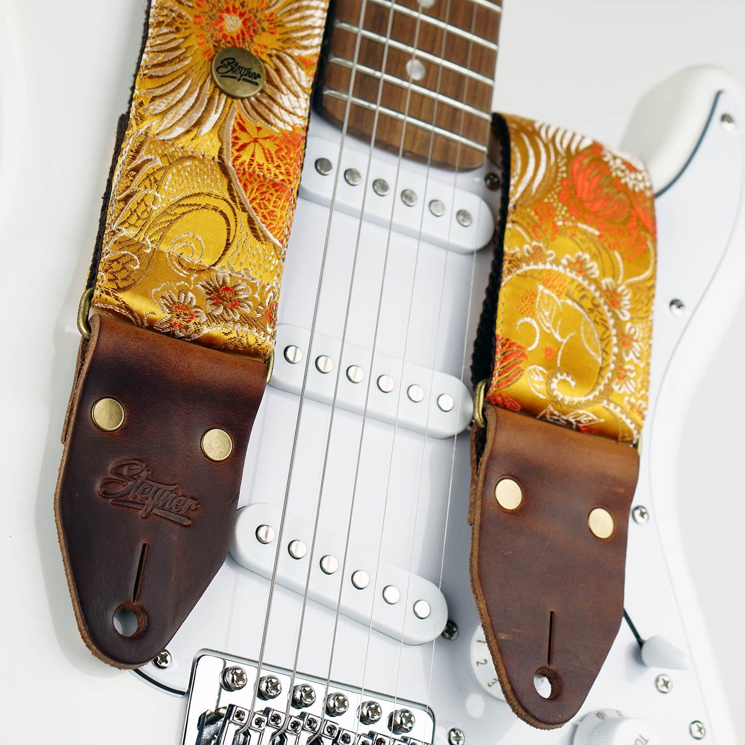 Bunter Gitarrengurt gelb im Vintage Stil und Blumen Muster auf einer weissen E-Gitarre