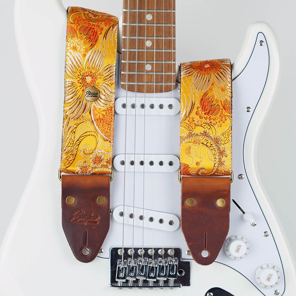 Gitarrengurt gelb im Vintage Stil und buntem Blumen Muster auf einer weissen E-Gitarre