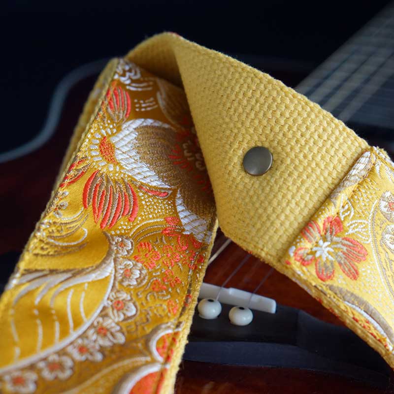 Gelber Gitarrengurt mit Blumenmuster und Glanz Effekt