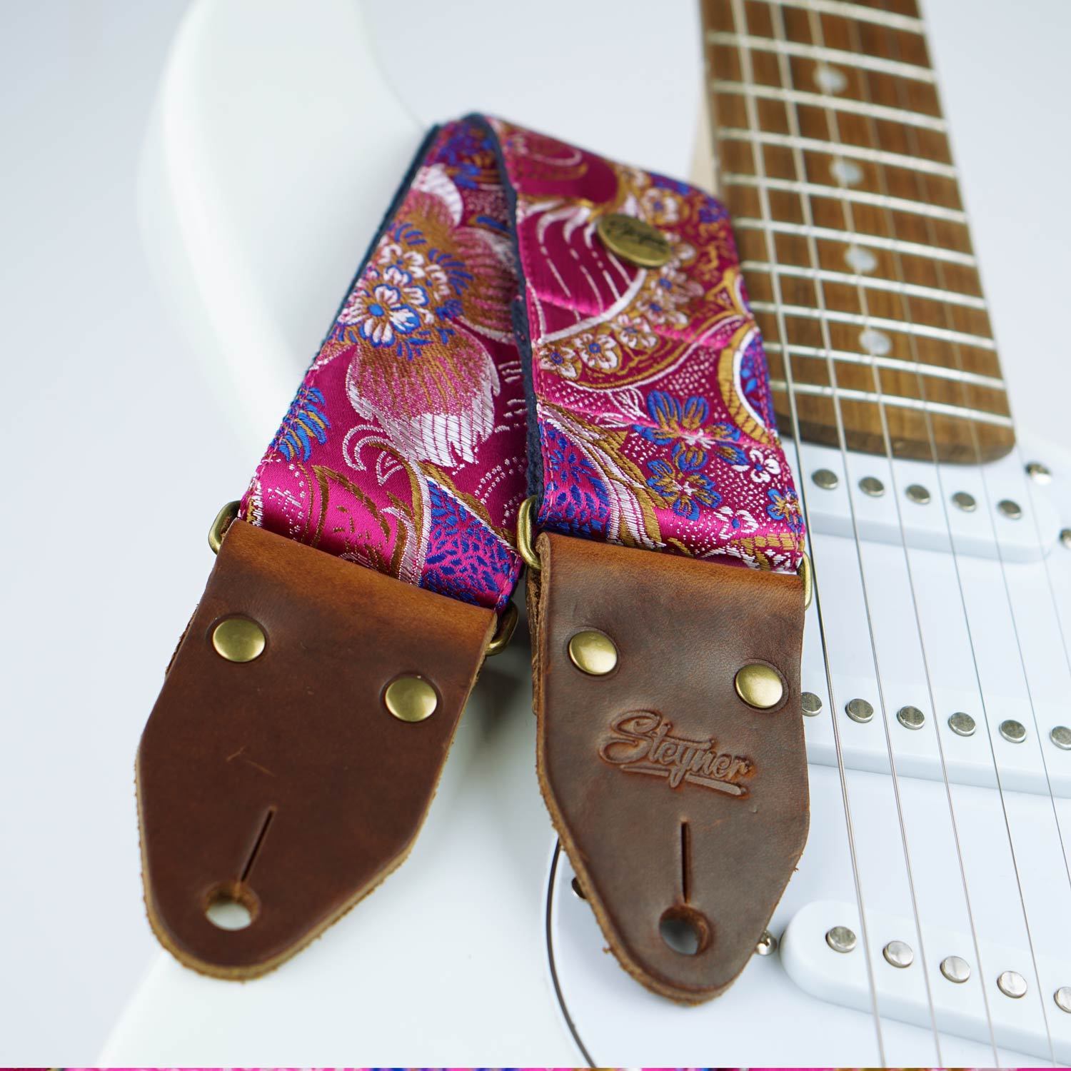 Vintage Gitarrengurt pink mit Blumen Muster auf einer weißen E-Gitarre