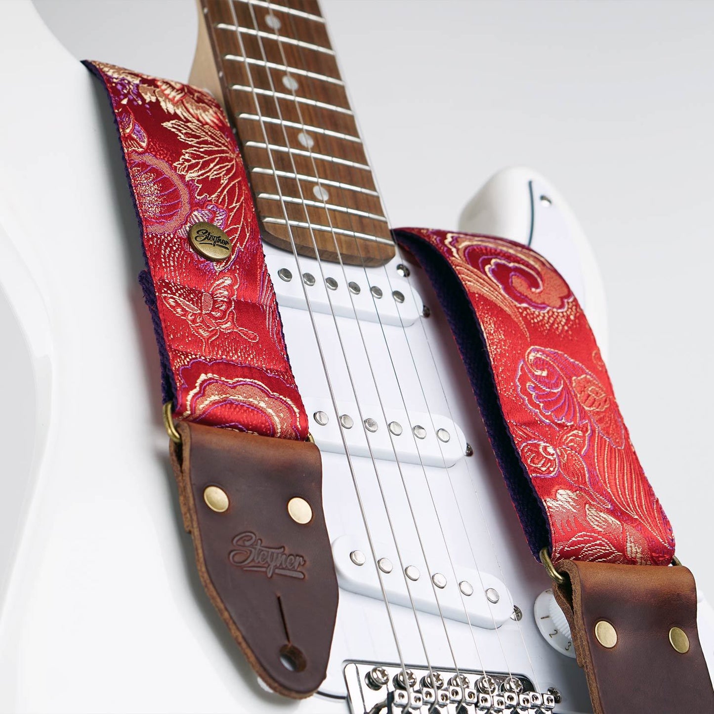 Gitarrengurt rot mit buntem retro Blumen Muster auf einer weissen E - Gitarre