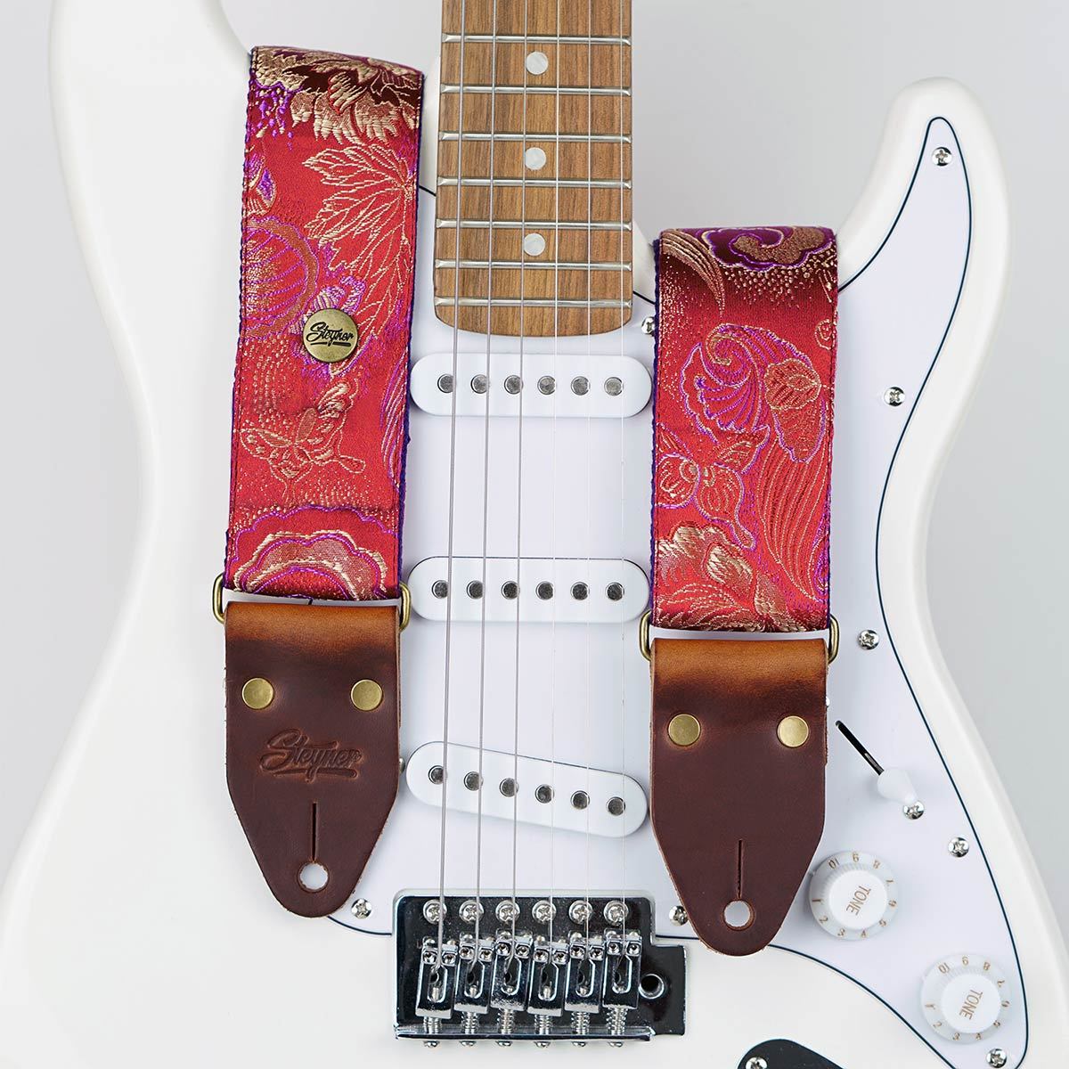 Gitarrengurt rot im vintage Stil mit Blumen Muster bestickt auf einer weißen E-Gitarre