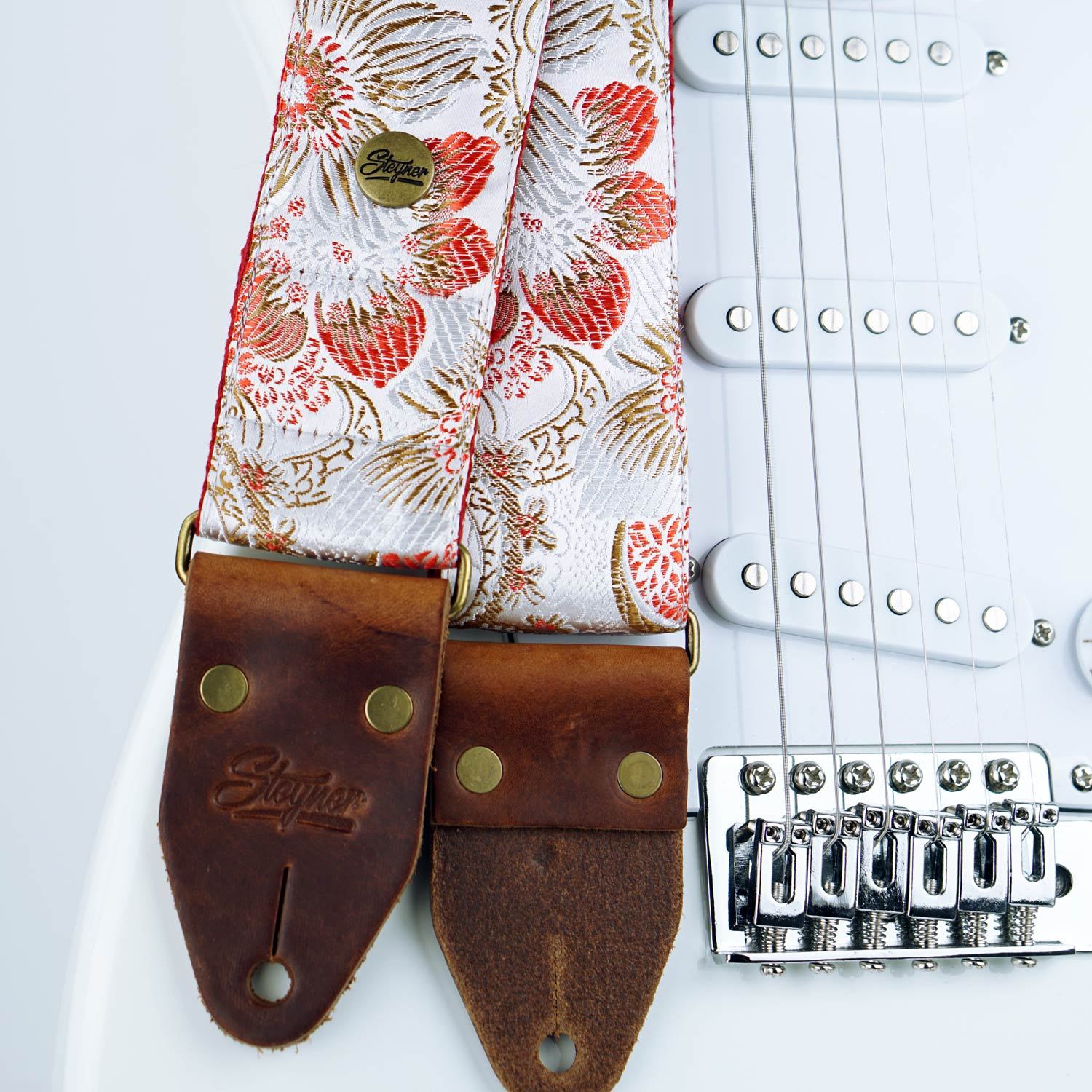 weisser Gitarrengurt im Vintage Stil mit retro Blumen Muster bunt auf einer weissen E-Gitarre