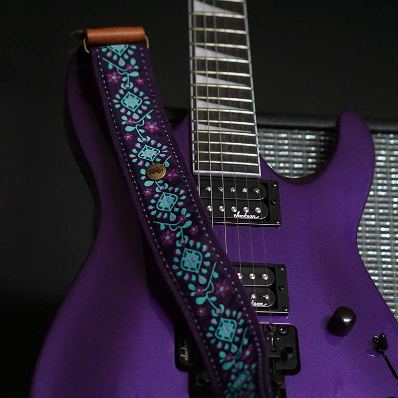 Lila Premium Gitarrengurt hochwertig mit Blumen Muster auf lila Gitarre und Fender Amp