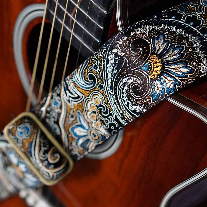 Schwarzer paisley Gitarrengurt auf einer Taylor Akustikgitarre