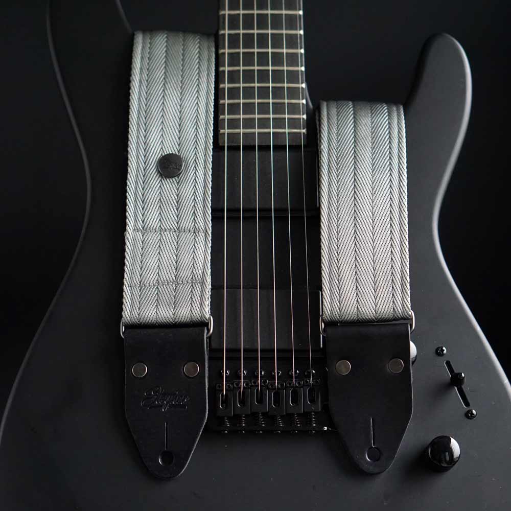 Gitarrengurt Nylon in silber grau auf einer schwarzen Strat von Steyner
